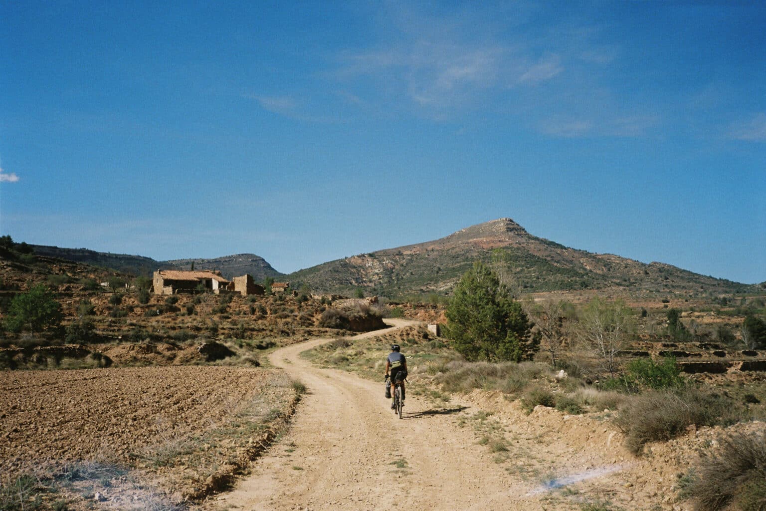 Ciclista de bikepacking recorriendo una pista entre montañas en el Camí dels Assagadors